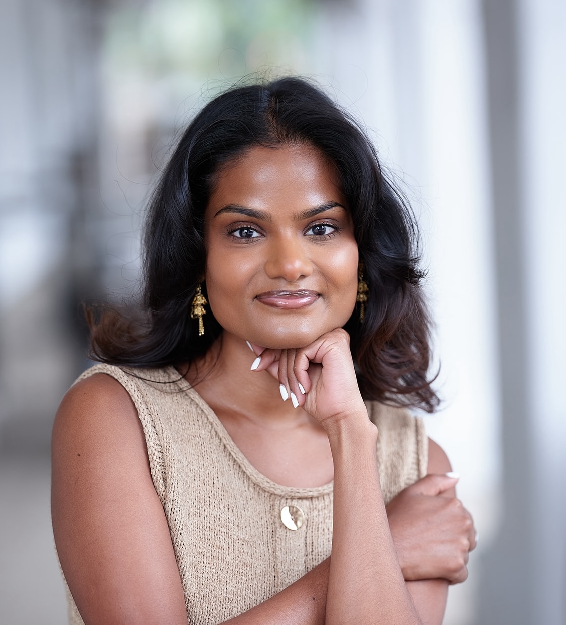 Saide Singh smiles at the camera with her hand on her chin.